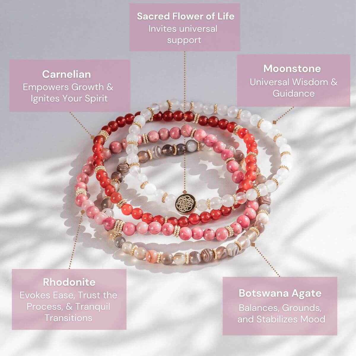 Four beaded bracelets in red, pink, and white with gold-tone medallion charms