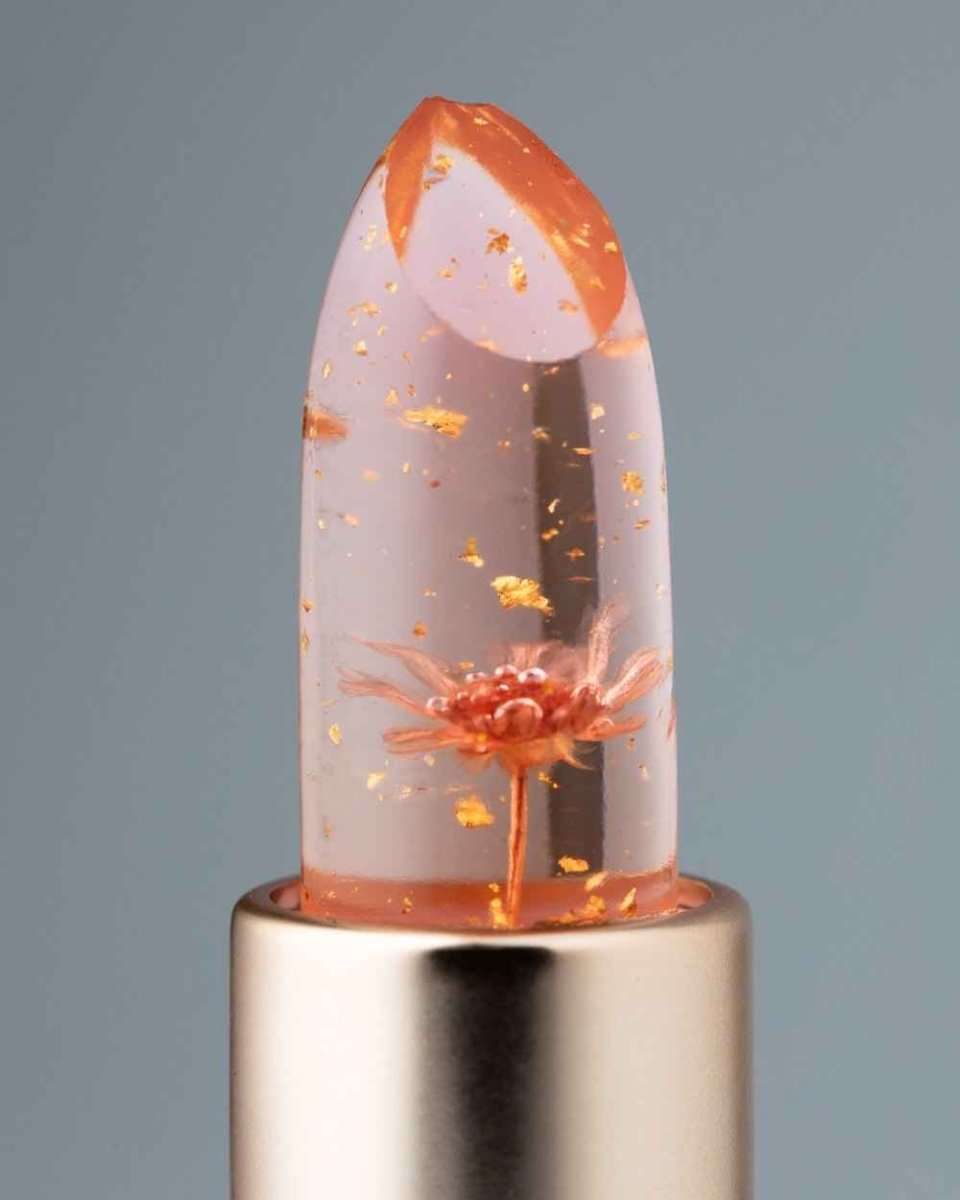Color-changing flower lip gloss close-up, clear orange floral dome on silver base