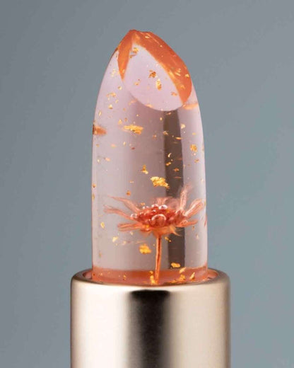 Color-changing flower lip gloss close-up, clear orange floral dome on silver base