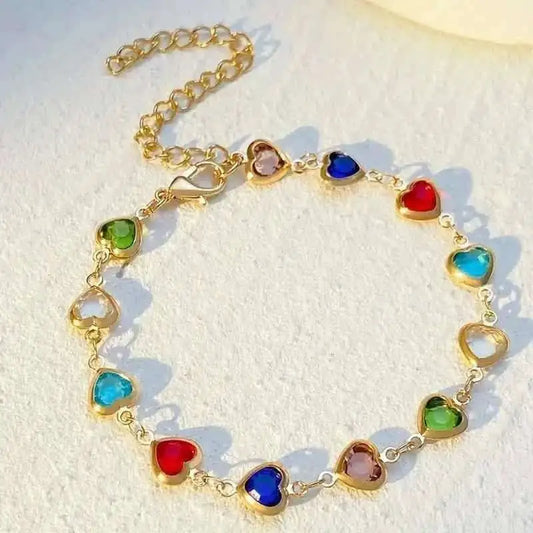 Gold-tone heart charm bracelet with multicolor zirconia-style stones on a link chain