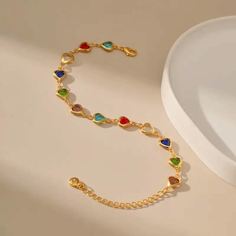 Gold-tone heart charm bracelet with multicolor zirconia-style stones on link chain
