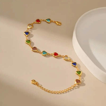 Gold-tone heart charm bracelet with multicolor zirconia-style stones on link chain