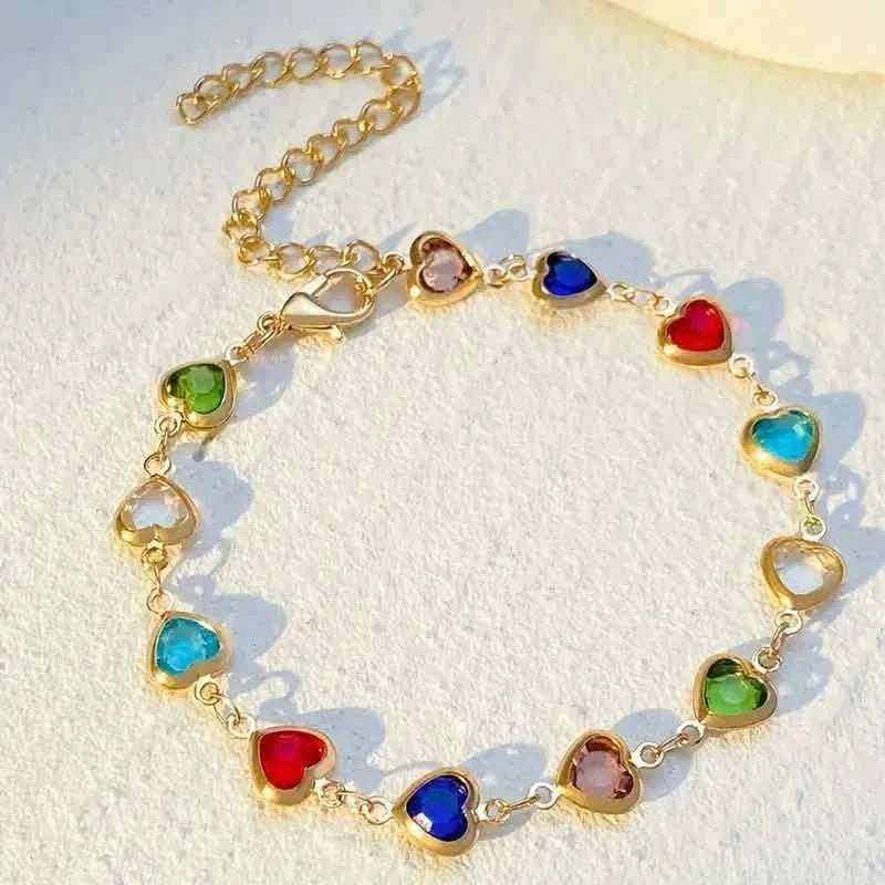 Gold-tone heart charm bracelet with multicolor zirconia-style stones on a link chain