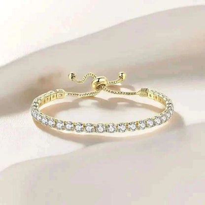 Gold-tone tennis bracelet with a row of clear stones and bow-style clasp