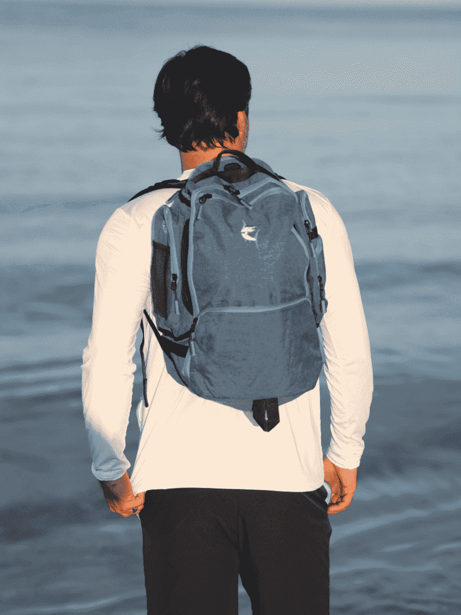 Blue day trip backpack on back with padded straps and top grab handle