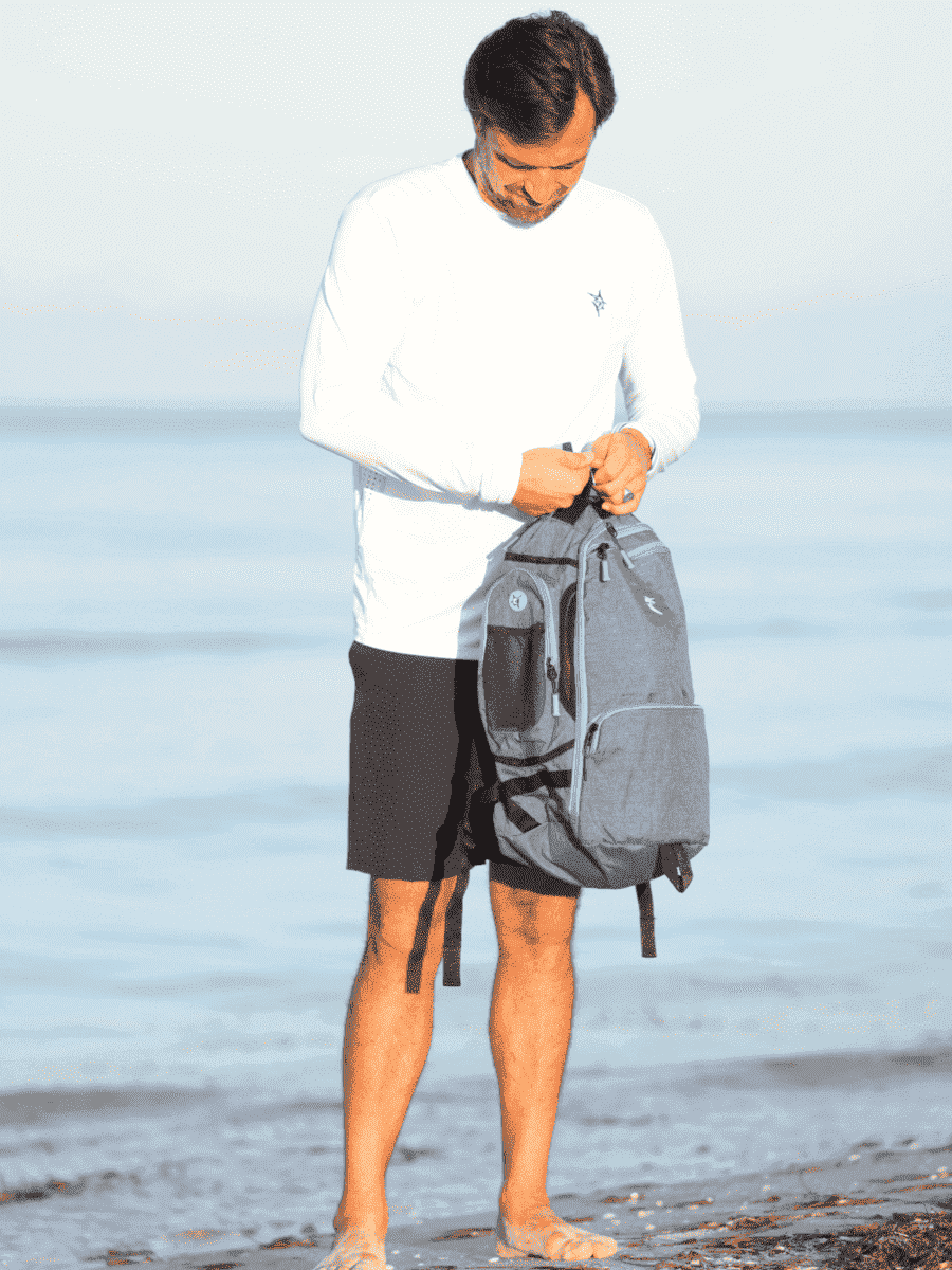 Blue day trip backpack held with short handle and front zip pocket