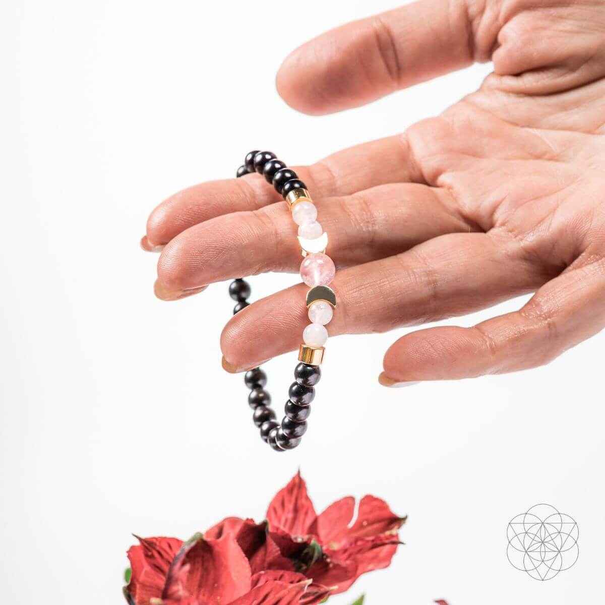 Shungite supercharged bracelet featuring black beads with pink stones and gold details