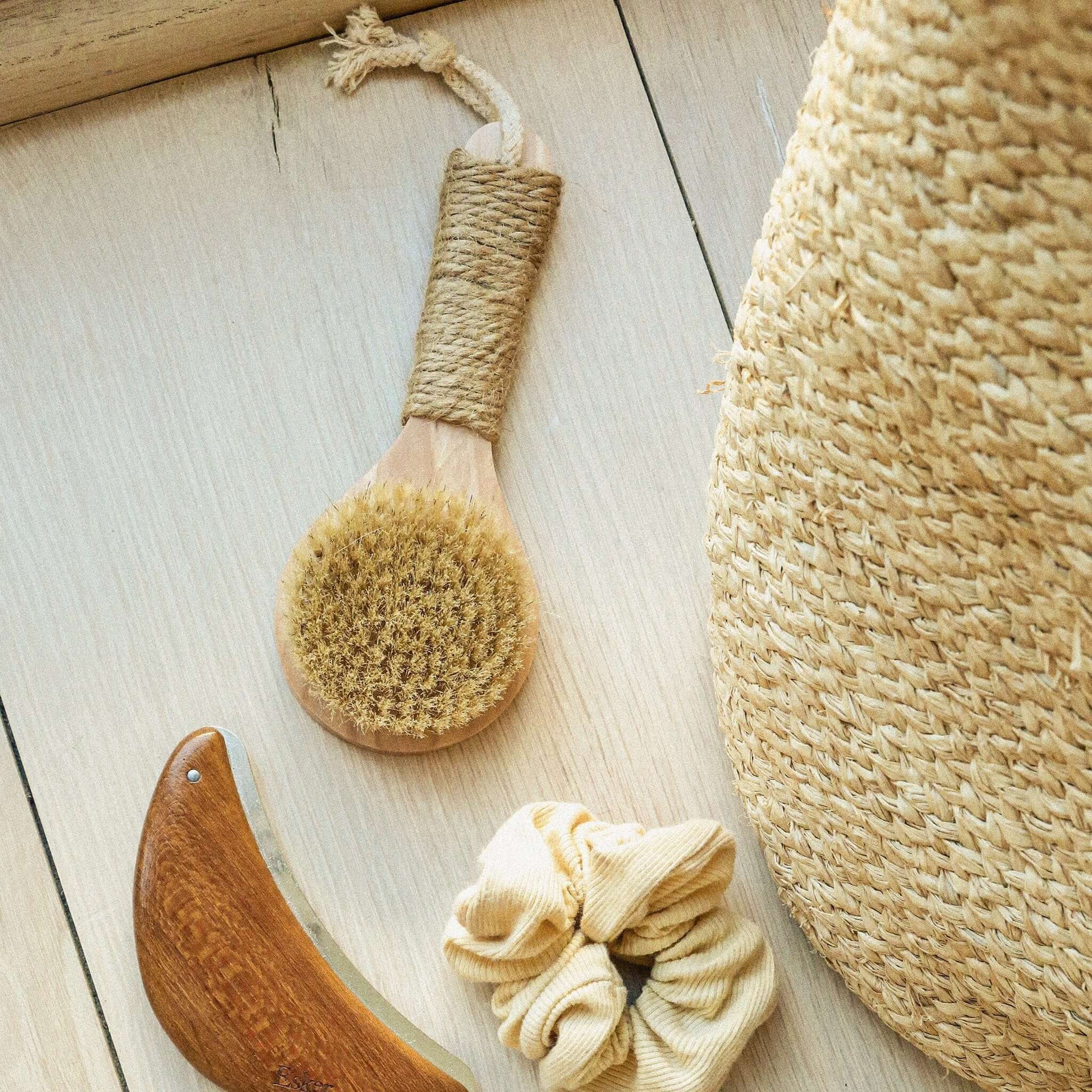 Natural bristle dry brush with woven hemp grip and loop, shown beside a hanging brush