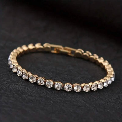 Gold-tone rhinestone tennis bracelet with round stones along a link band