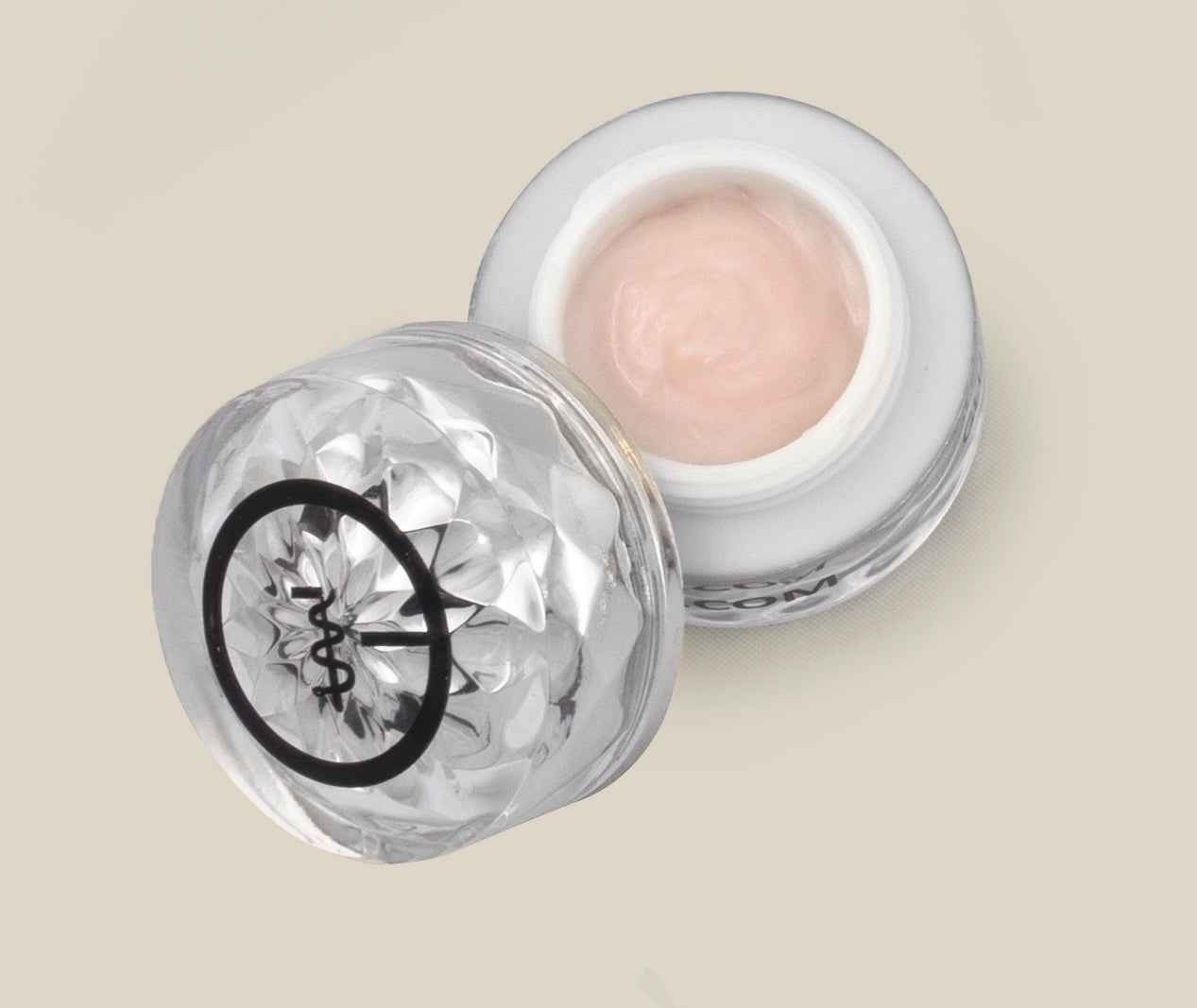 Eye cream jar with open lid showing pale pink cream inside clear container