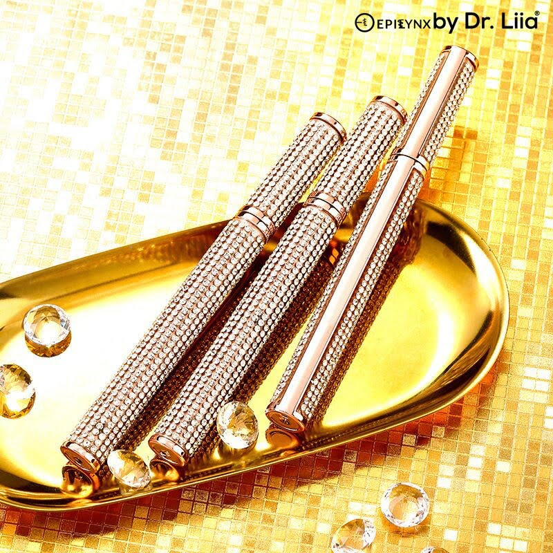 Rhinestone mascara tubes with gold caps laid on reflective tray