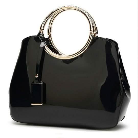 Black handbag with gold ring handles and hanging charm tag