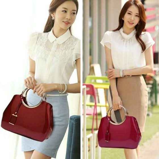 Red handbag with gold ring handles and hanging charm tag on model