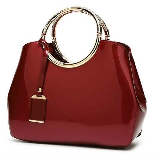 Wine red handbag with gold ring handles and hanging charm tag