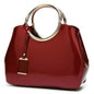 Wine red handbag with gold ring handles and hanging charm tag