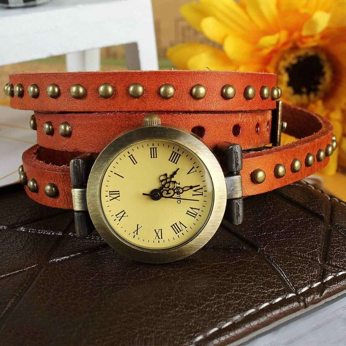 Retro leather belt watch with cream dial, studded orange-brown leather strap.