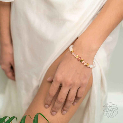 Beaded bracelet on wrist with pink and white beads and small gold-tone accents.