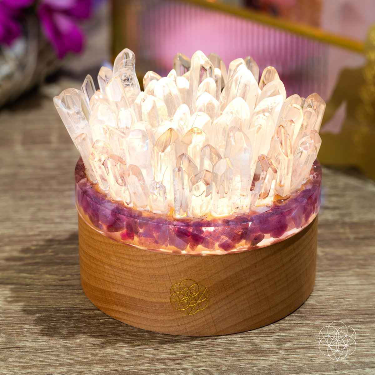 Quartz and tourmaline crystal lamp with clear pointed crystals and round wooden base, lit