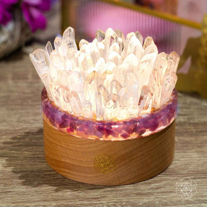 Quartz and tourmaline crystal lamp with clear pointed crystals and round wooden base, lit