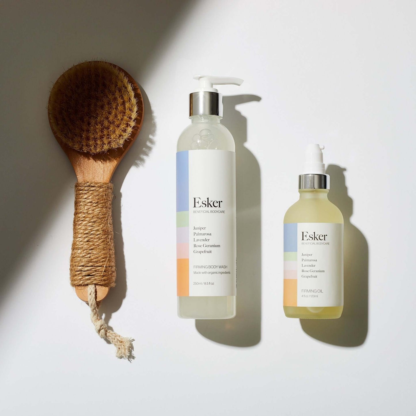 Body brush with two Esker pump bottles of firming skincare oil