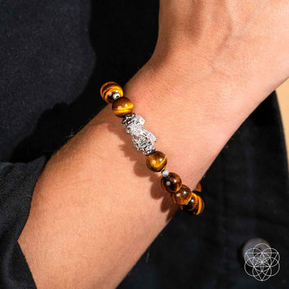 Tiger’s eye bead bracelet with silver Pixiu charm on wrist