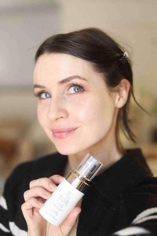 Woman holding EpiLynx gentle exfoliating face scrub bottle with gold pump