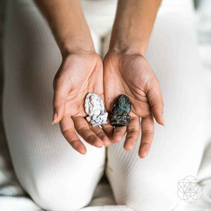 Crystal Ganesh statues held in hands: white howlite and dark blue labradorite