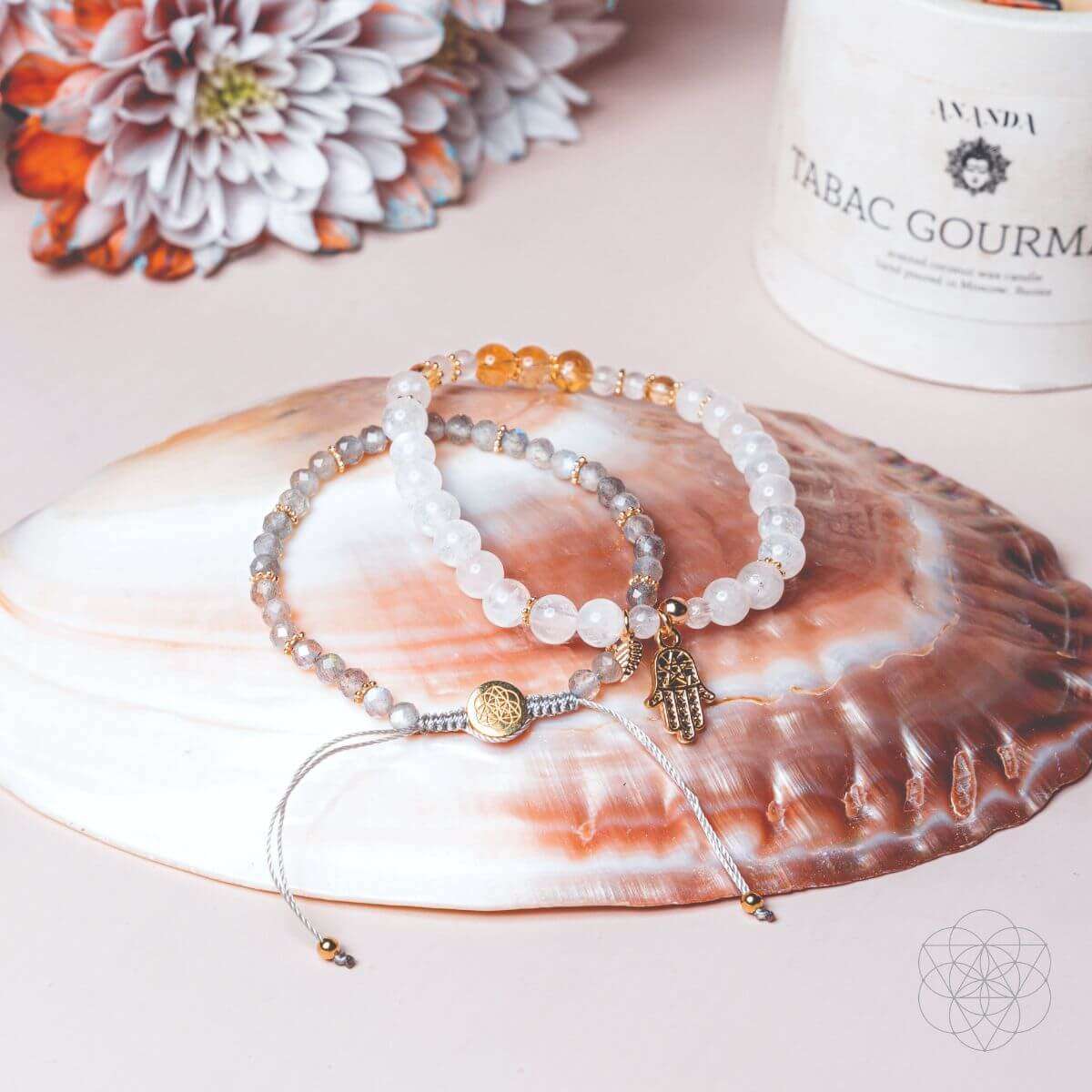 Triple bracelet set with white bead strands, gold accents, and small Hamsa charm