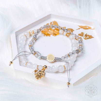 Bracelet set laid in jewelry box with white beads and gold hand charm