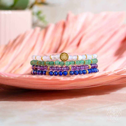 Four-piece beaded luck bracelet set with gold charm, purple, blue, green and white