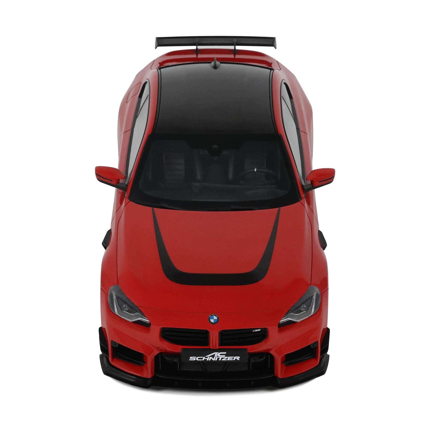 Red die-cast model car front view with black grille, headlights, and roof spoiler