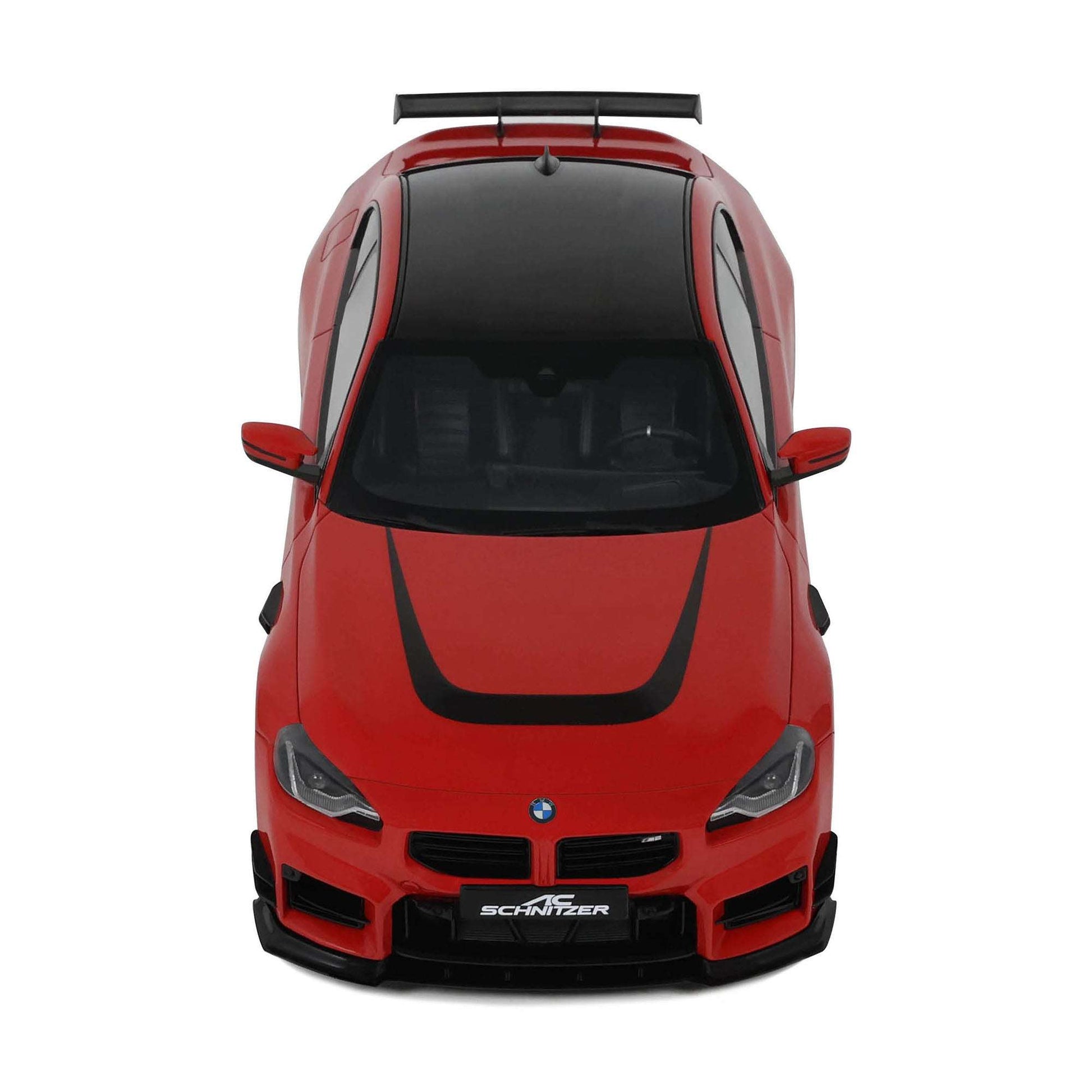 Red die-cast model car front view with black grille, headlights, and roof spoiler