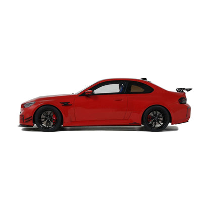 Red die-cast sports car model side profile with black wheels and rear spoiler