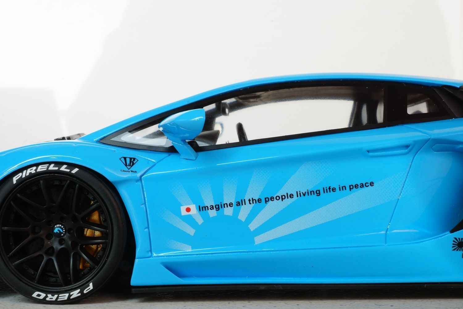Baby blue die-cast sports car model, side door and front wheel close-up
