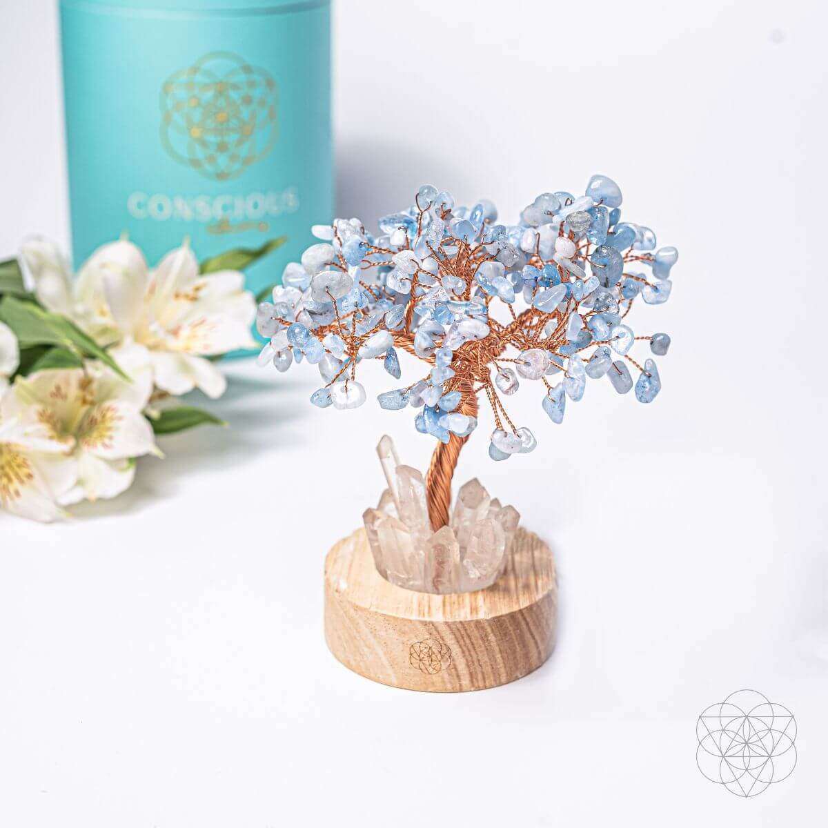 Aquamarine blue crystal tree lamp on round wood base with white rose quartz rocks