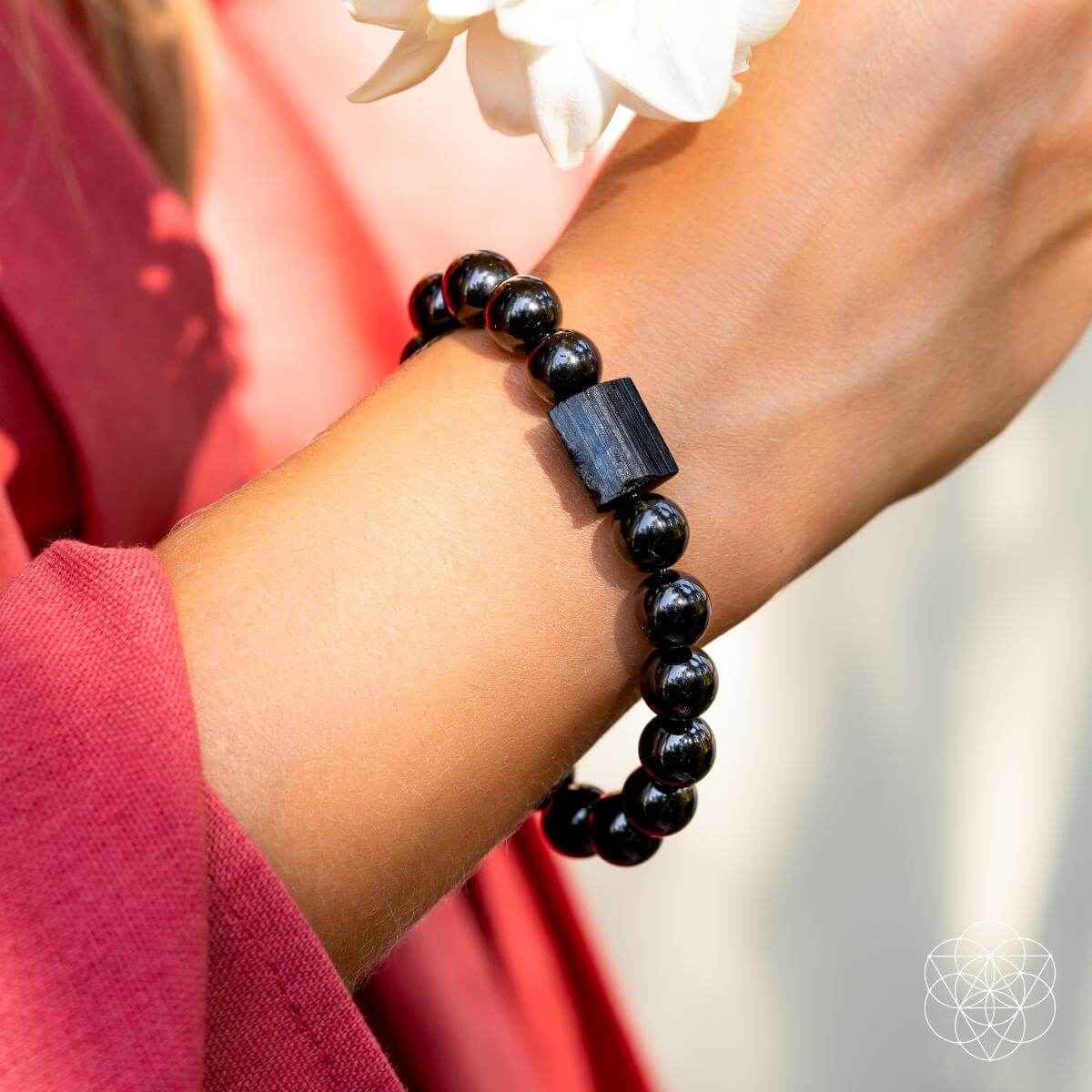 Black obsidian beaded bracelet on wrist with dark rectangular centerpiece