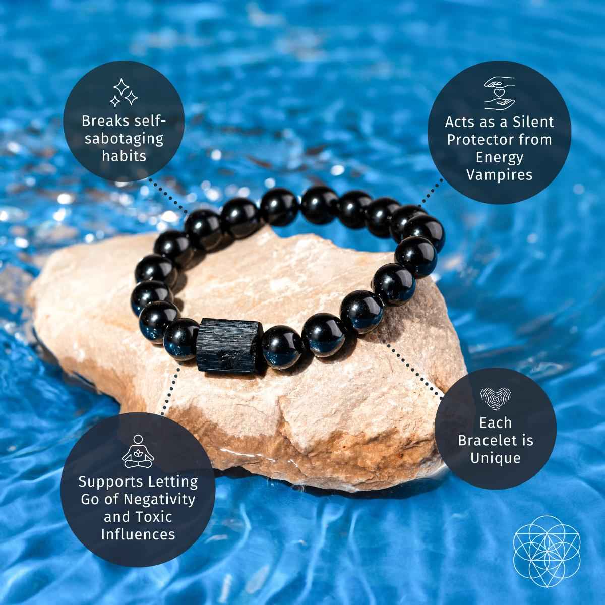 Black obsidian beaded bracelet with dark rectangular charm on light stone
