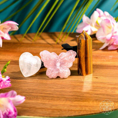 Car crystal safety kit on wooden surface: tiger-eye pyramid, pink butterfly and white heart