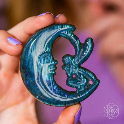 Hand holding blue labradorite moon carving with cutout center