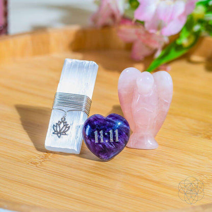 Rose quartz angel and purple 11:11 amethyst heart beside stacked metal vent clip
