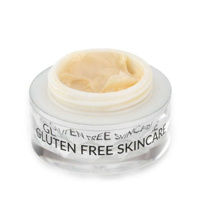 Eye cream jar with open lid and beige cream inside, clear faceted container
