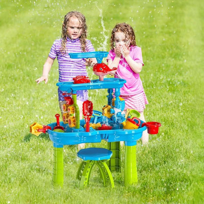 Kids sand and water table with blue basin, red fish figure, green legs, and sand tools