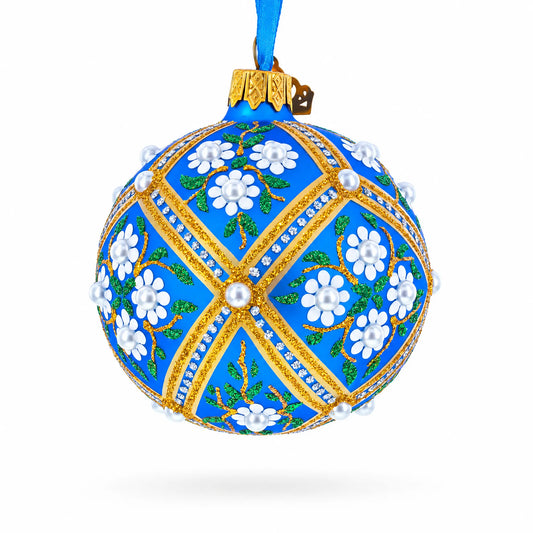Blue glass Christmas ball ornament with gold trim and white floral details