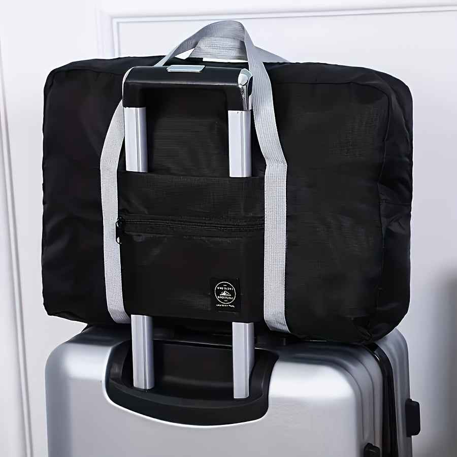 Black nylon duffel bag with front zip pocket and light gray shoulder straps