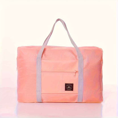 Pink nylon foldable duffel bag with front zip pocket and gray carry handles