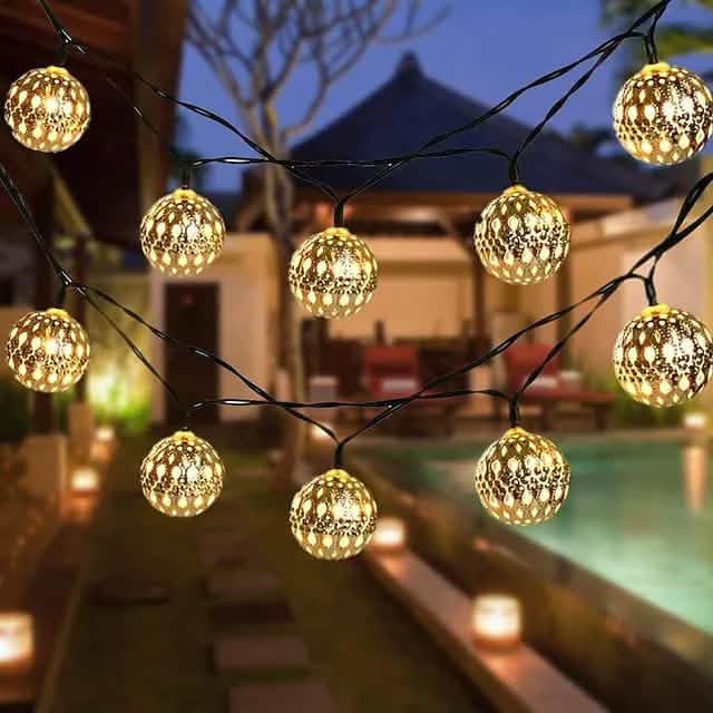 LED solar string lights with warm white globe bulbs hanging on an outdoor veranda