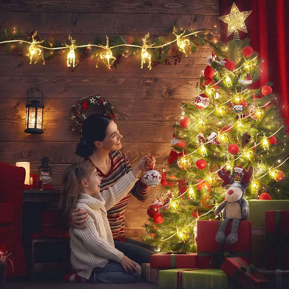 Warm white LED reindeer string lights around a Christmas tree with glowing deer figures