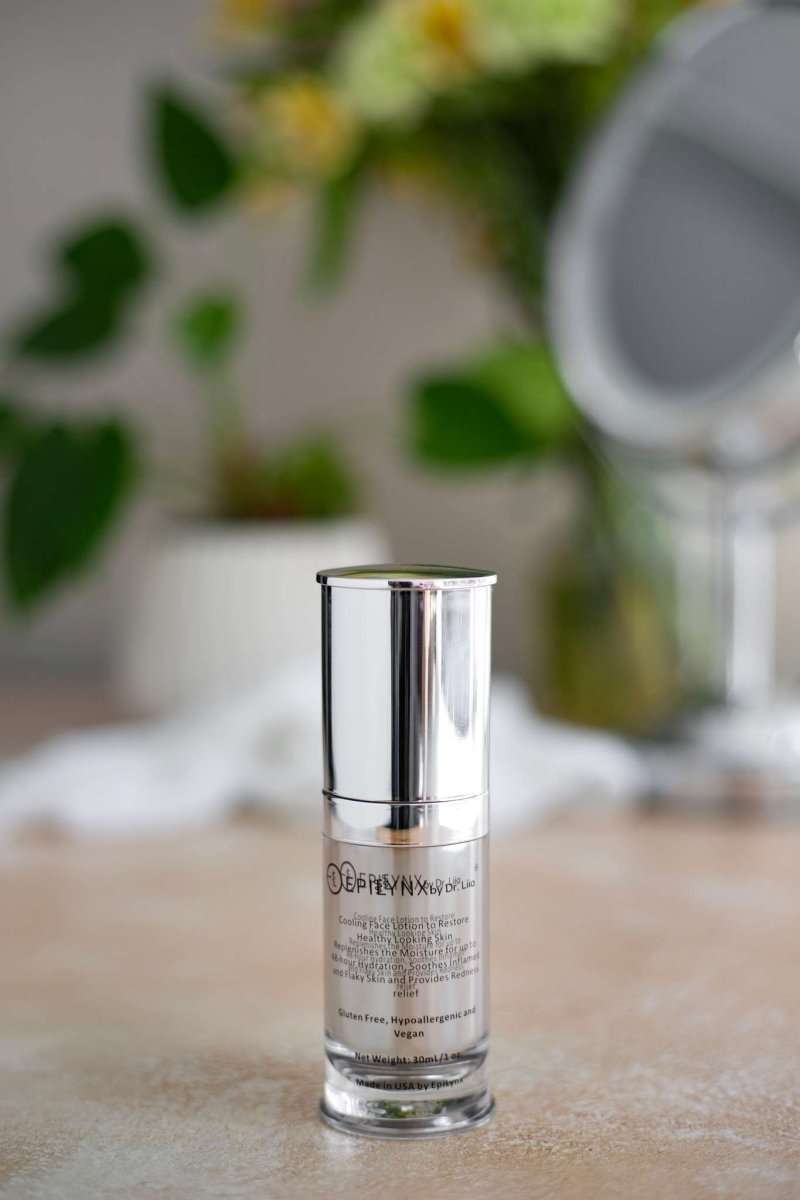Silver face moisturizer bottle with cylindrical cap and clear base