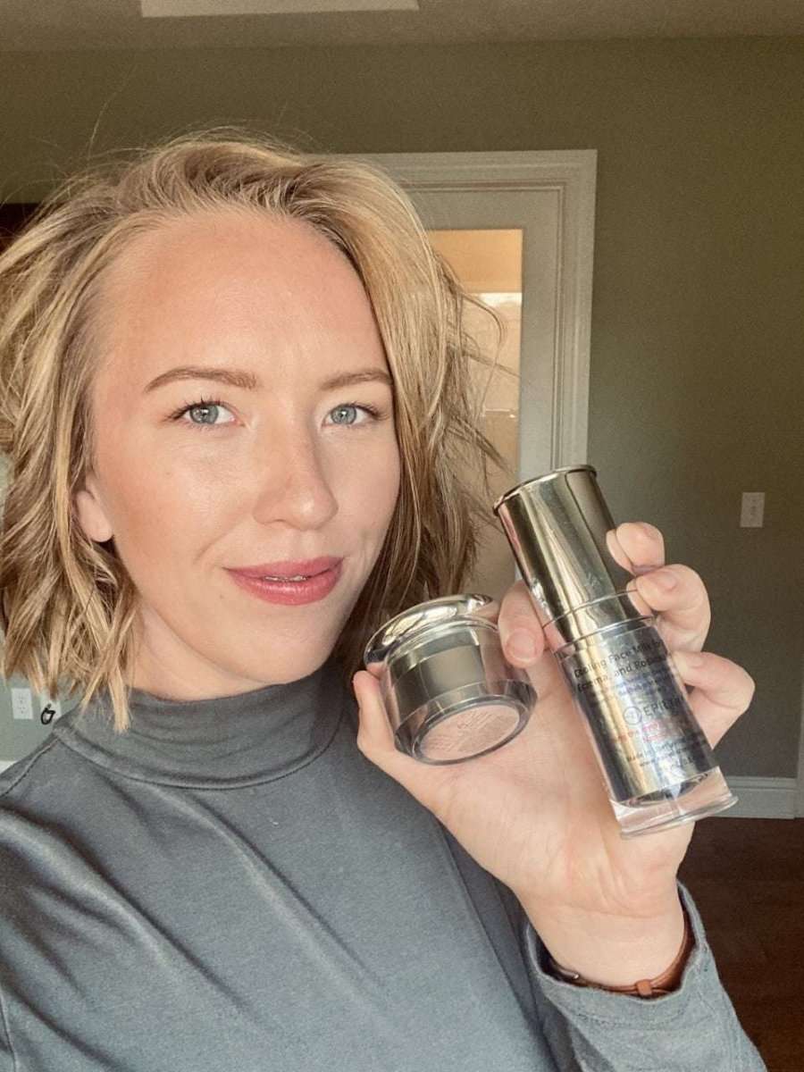 Face moisturizer bottle held in hand and reflected in mirror