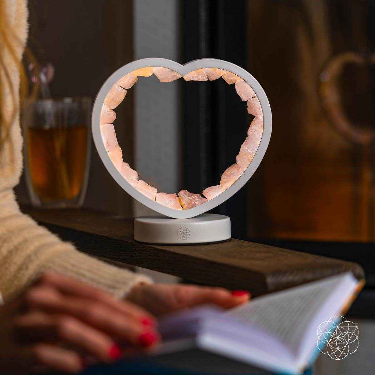 Heart-shaped rose quartz lamp on a gray base, angled view